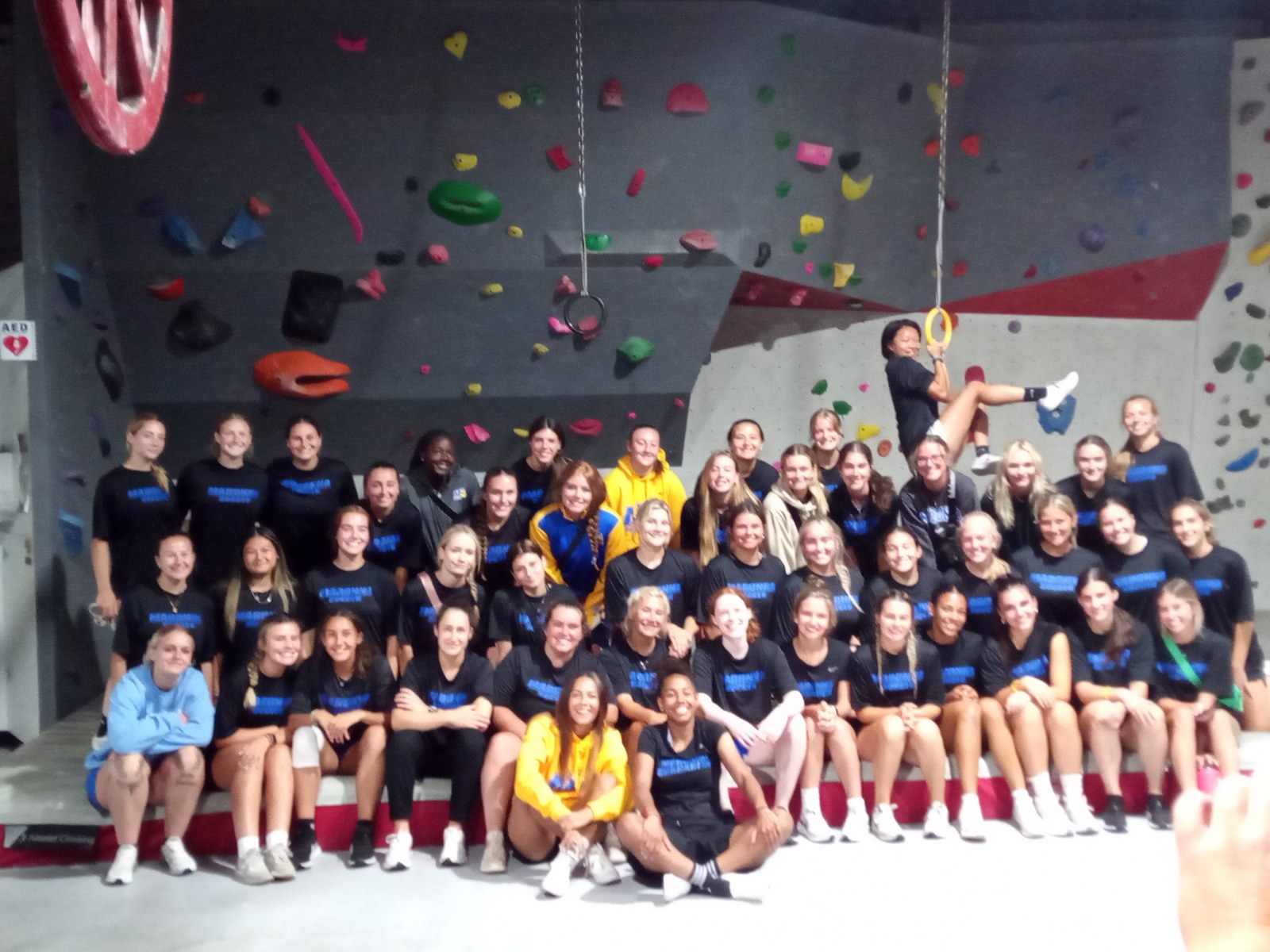 College team celebrating at Gripz climbing wall